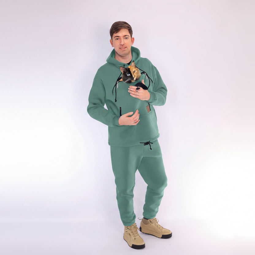 Person wearing a Emerald Green hoodie and pants with a unique design, holding a cat.