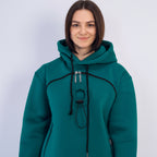 Teal hoodie with black accents and a brown patch on a white background