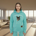 Person wearing a mint hoodie with a dog in a modern living room.