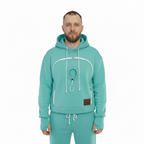 Man wearing a mint hoodie and pants set on a white background