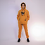 Person wearing a mustard yellow hoodie and pants with a dog on a white background