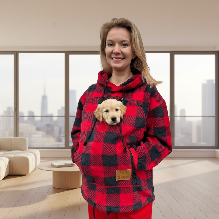 Person wearing a red and black checkered hoodie with a puppy inside, standing against a plain background.