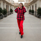 Woman wearing a red and black checkered outfit in an outdoor setting