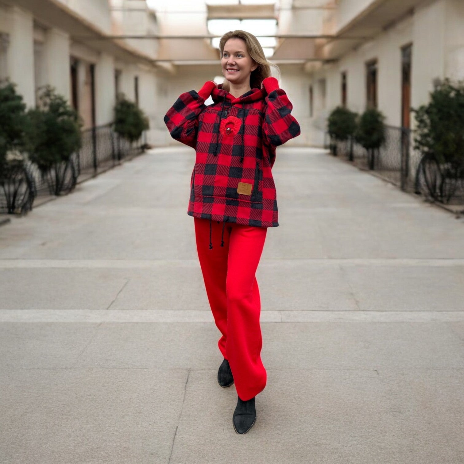 Woman wearing a red and black checkered outfit in an outdoor setting