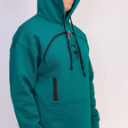 Teal hoodie with black zippers on a light gray background