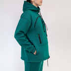 Person wearing a teal tracksuit with black accents on a white background