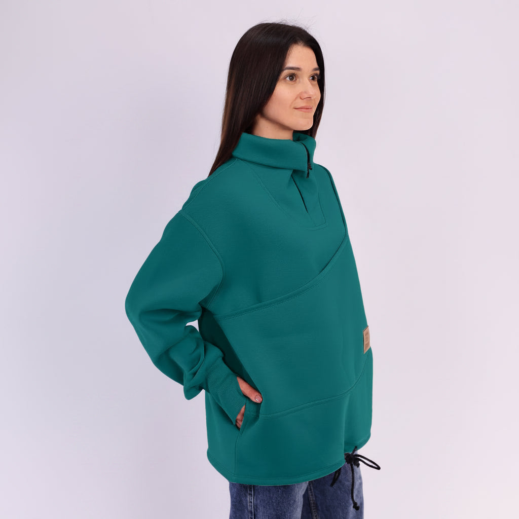 Woman wearing a teal sweatshirt on a white background