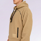 Beige fleece hoodie with black drawstrings on a light purple background