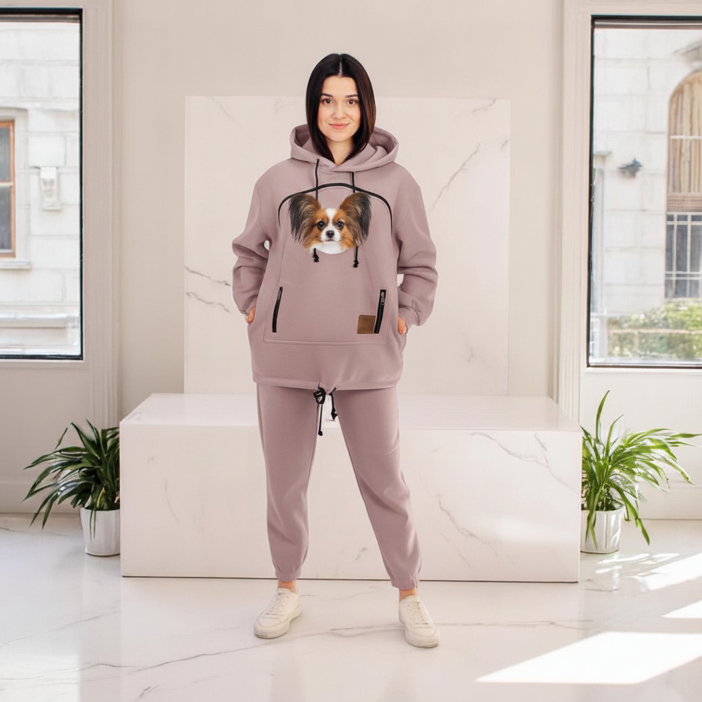 Person wearing a beige cappuccino hoodie and pants with a dog in a modern indoor setting.