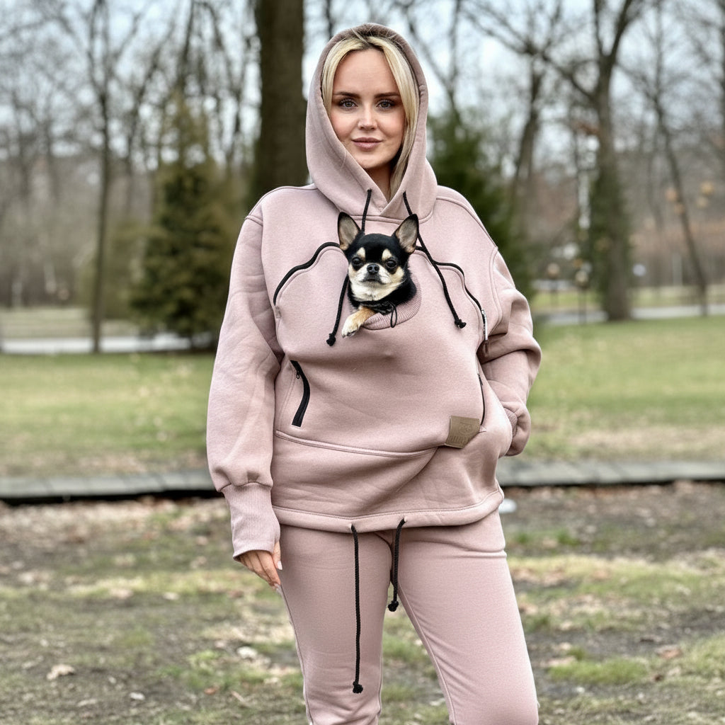 Person wearing a beige hoodie with a dog outdoors