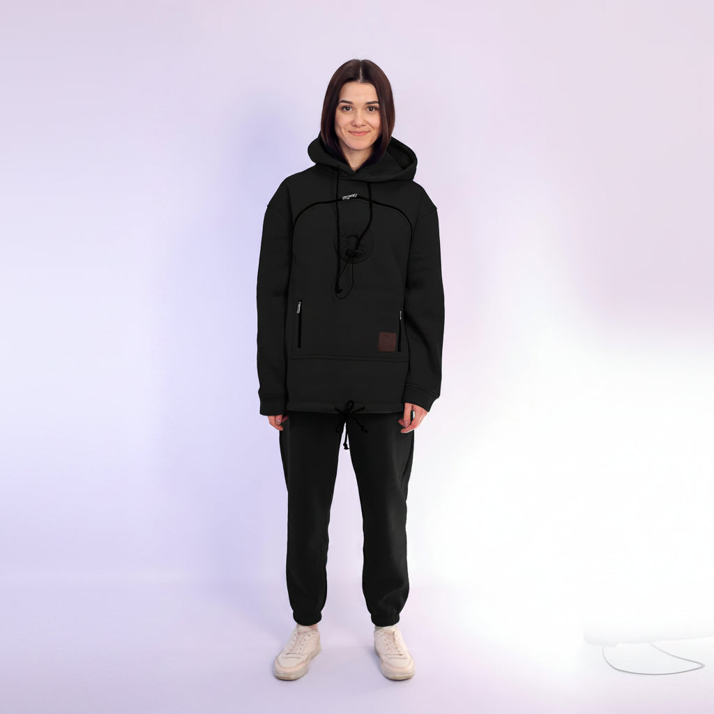 Person wearing a black hoodie and pants on a white background