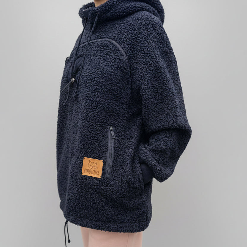 Black boucle fleece pullover with a brand patch on a gray background