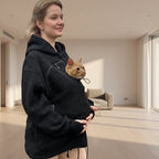 Woman holding a red cat in a black boucle jacket