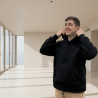 Man wearing a black boucle hoodie standing in a room