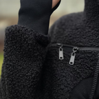 Close-up of a textured hoodie with a zipper detail.