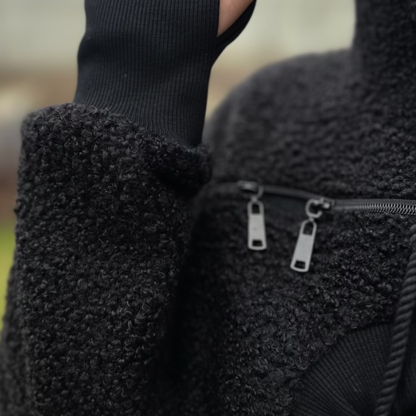 Close-up of a textured hoodie with a zipper detail.