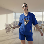 Person wearing a blue t-shirt with a dog in the pouch in a modern living room.