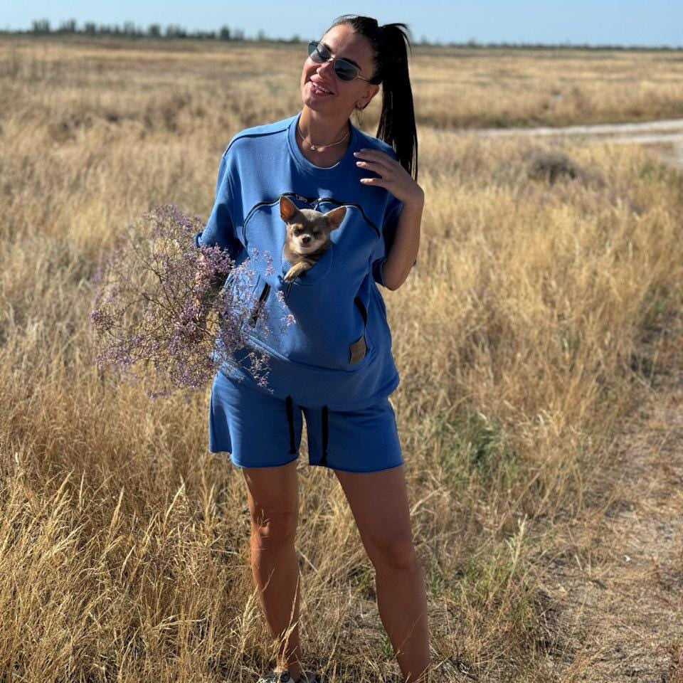 Woman in a blue outfit with a dog in a field