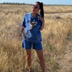 Woman in a blue outfit with a dog in a field