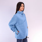 Woman wearing a light blue fleece pullover on a white background