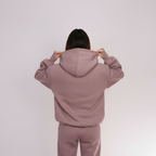 Person wearing a light brown hoodie from behind on a white background