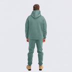 Person wearing a emerald tracksuit on a white background