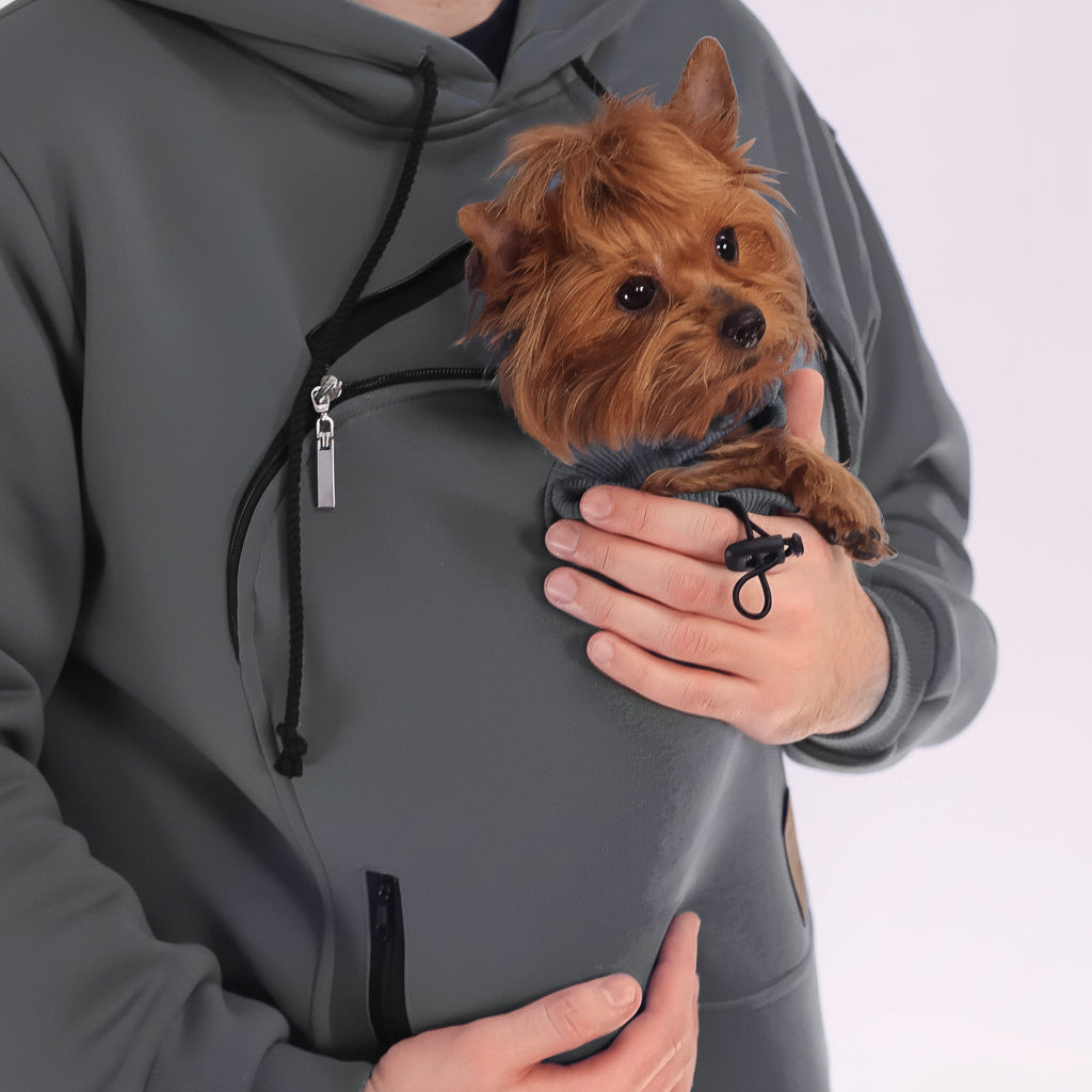 Person wearing a gray hoodie with a dog in Pouch