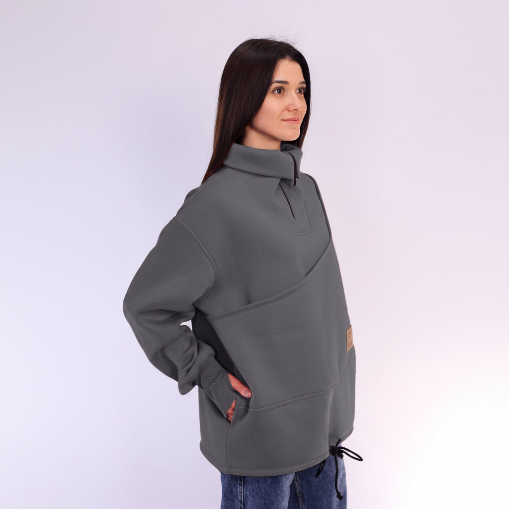 Woman wearing a gray fleece sweatshirt on a white background