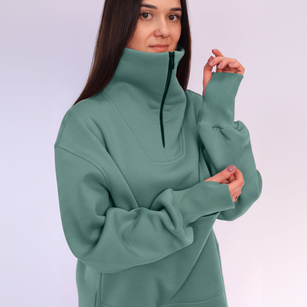 Woman wearing a green high-neck sweater against a white background