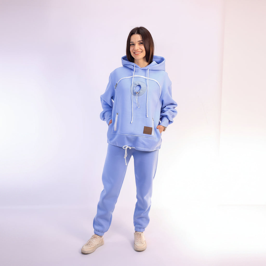 Person wearing a light blue hoodie and pants set on a white background