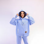 Person wearing a light blue hoodie and pants on a white background