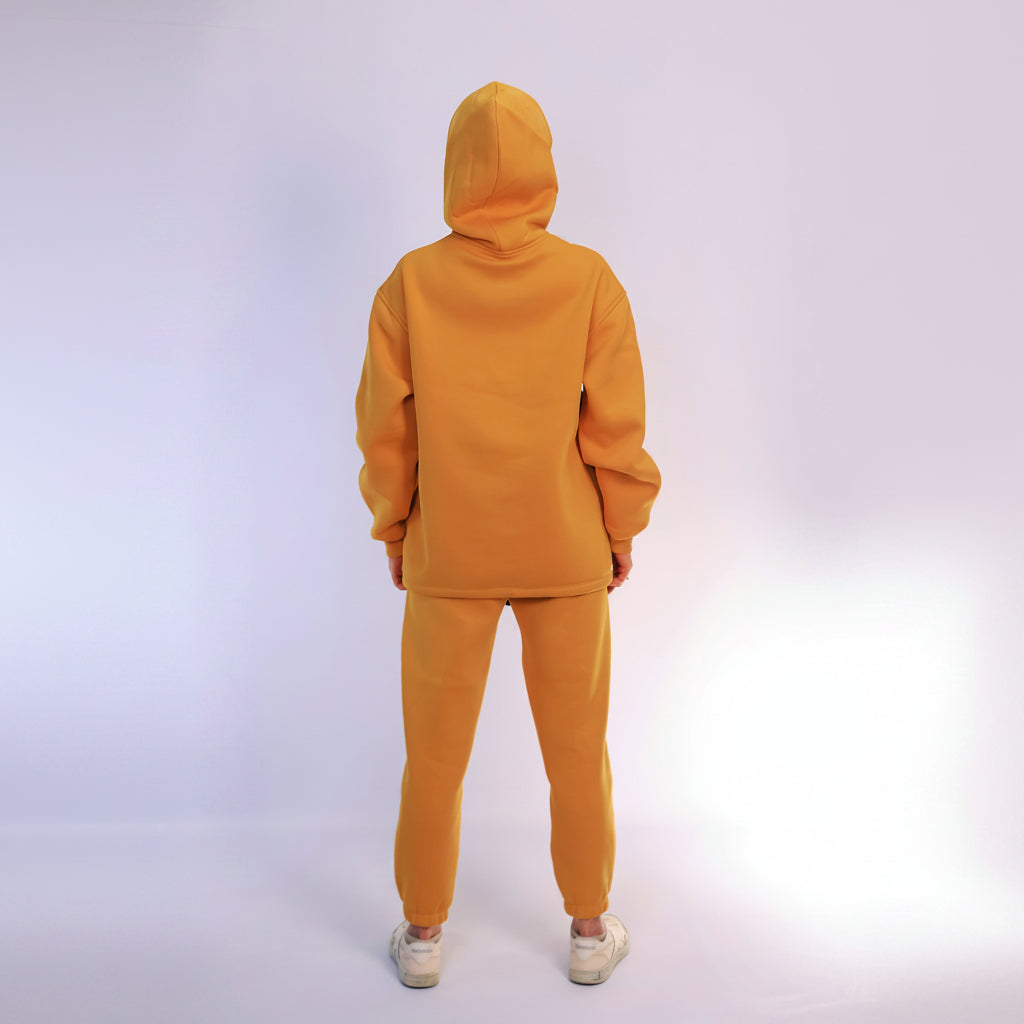 Person wearing a mustard tracksuit on a white background