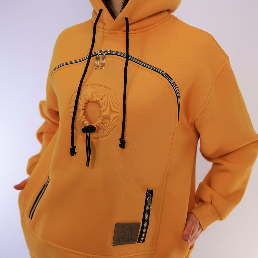 Mustard hoodie with black drawstrings and zippers on a white background