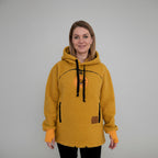 Woman wearing a orange fleece hoodie with black drawstrings in a home setting