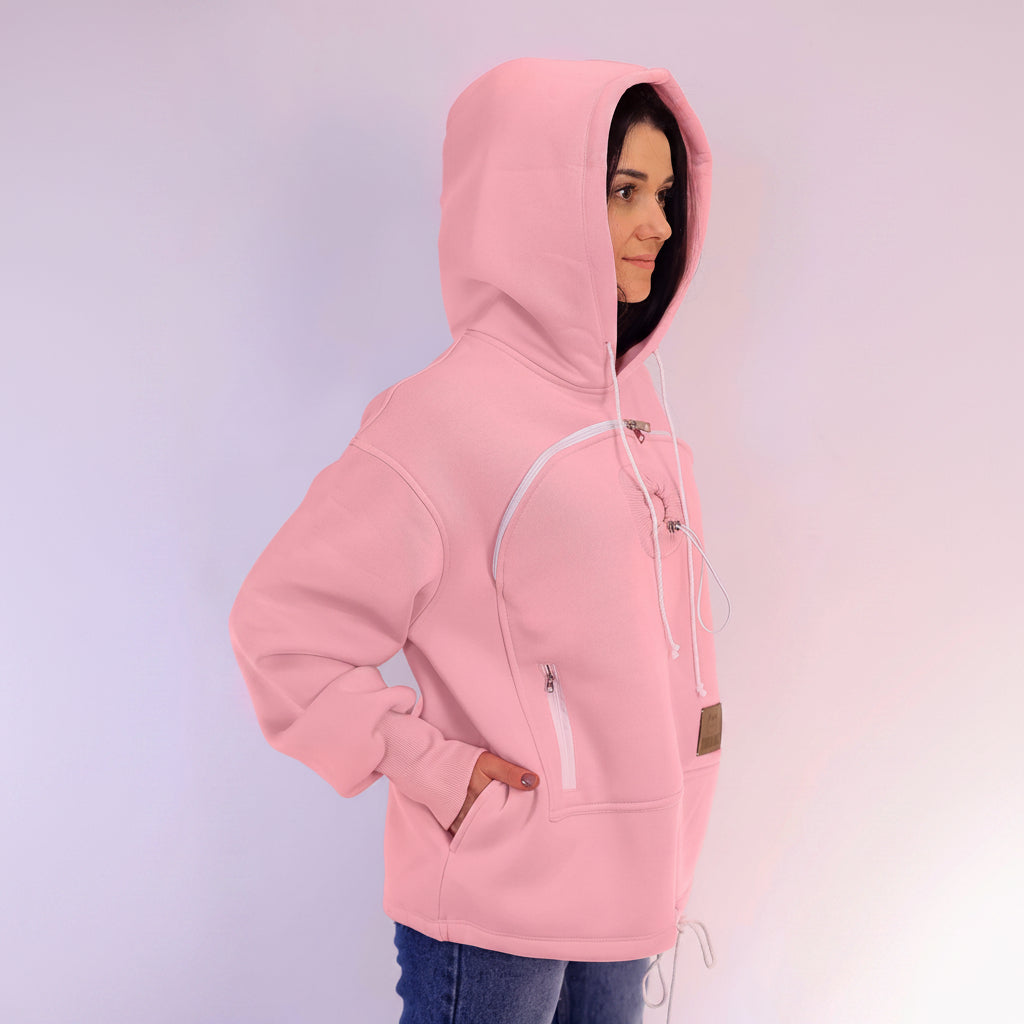 Person wearing a pink hoodie with zippers on a light purple background