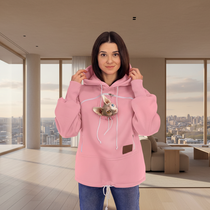Woman wearing a pink hoodie with a cat design in a modern living room.
