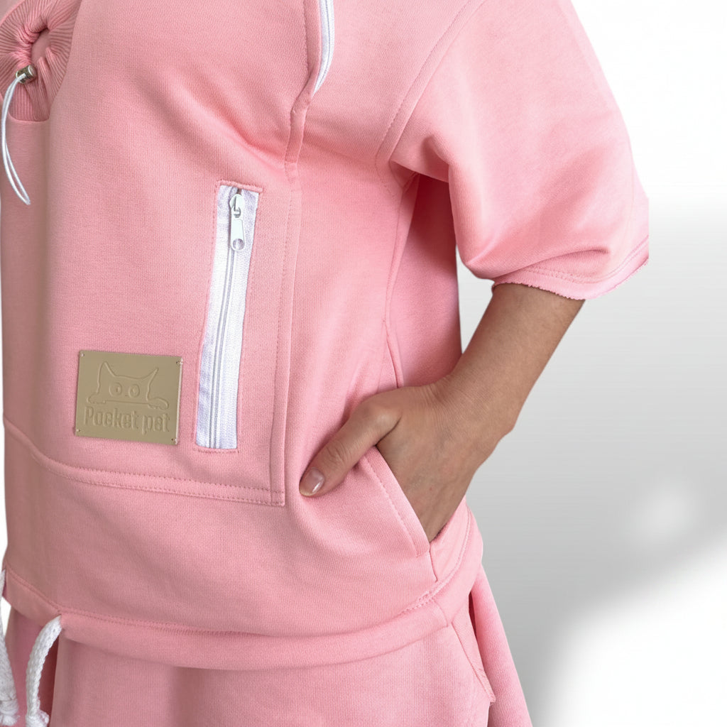 Pink tracksuit with a visible brand logo on a light gray background
