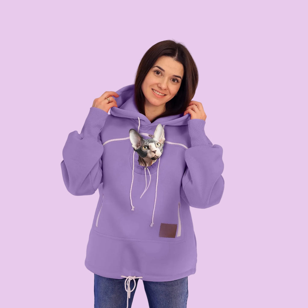 Person wearing a purple hoodie with a small dog on a white background