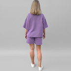 Person wearing a purple outfit on a gray background