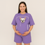 Person wearing a purple outfit with a dog graphic on a plain background