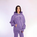 Person wearing a purple hoodie and pants on a white background