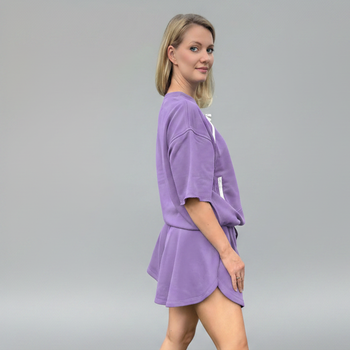 Woman wearing a purple outfit on a gray background