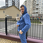 Men wearing a royal blue onesie with a cat inside, standing on a street with buildings in the background.