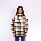 Woman wearing a beige plaid sweatshirt on white background