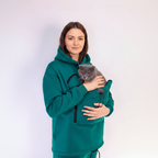 Person wearing a teal hoodie with a cat inside, on a white background