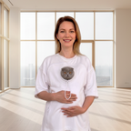 Woman wearing a white outfit with a cat face, standing in a room with large windows.