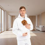 Man wearing a white hoodie holding a small brown dog on a white background