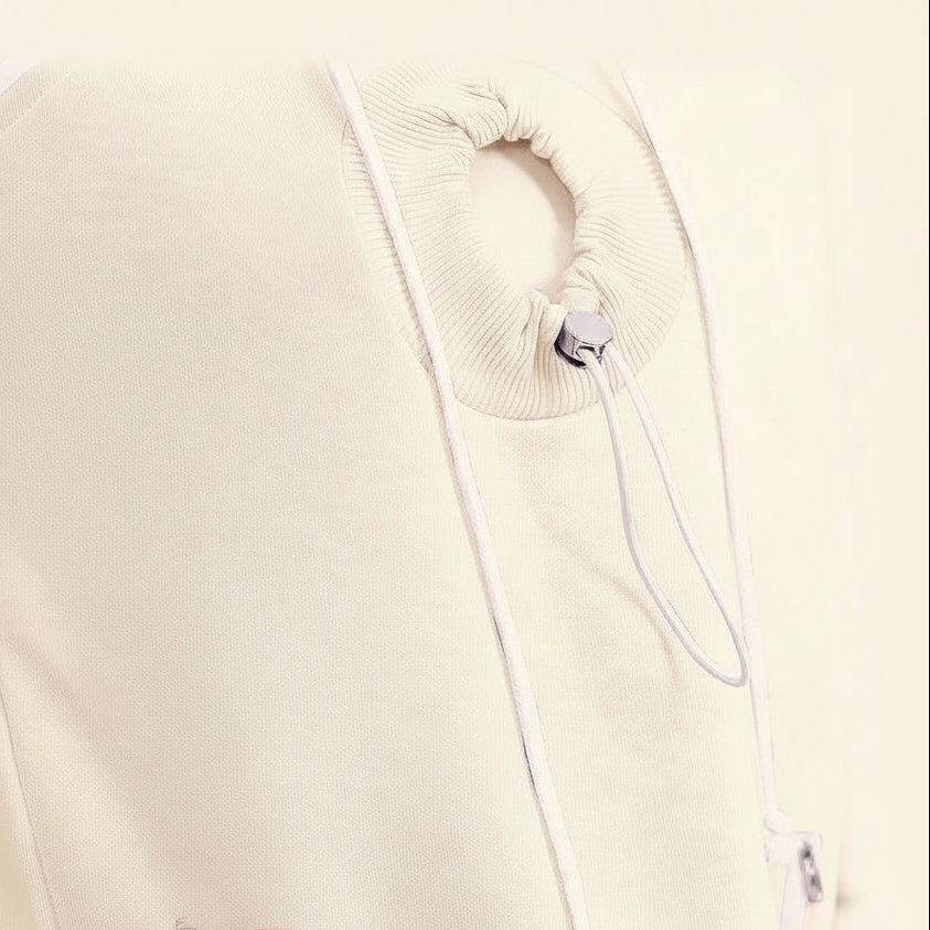 Close-up of a white garment with drawstrings and a hand holding it.