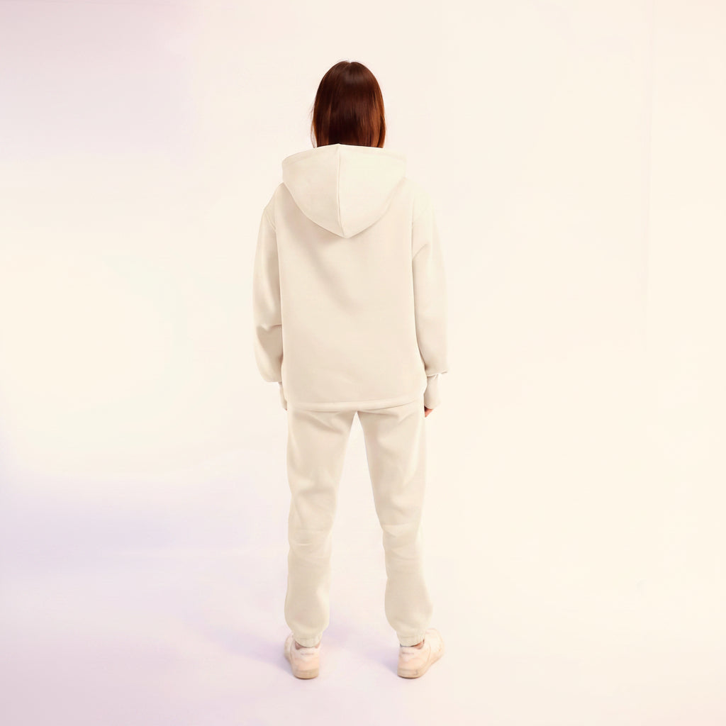 Person wearing a white  hoodie and pants set on a white background