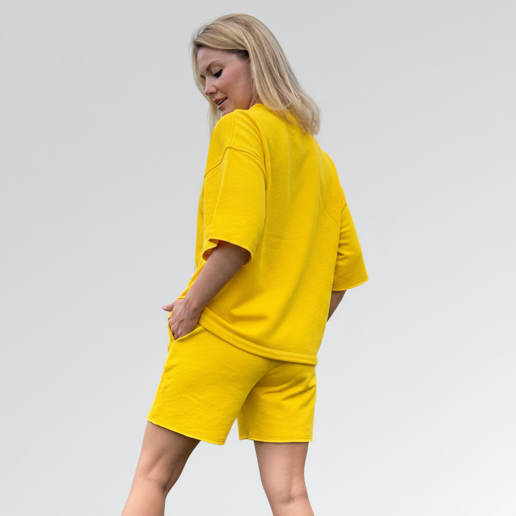 Woman wearing a yellow outfit on a light gray background